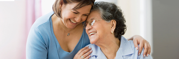 Middle aged woman hugging older woman